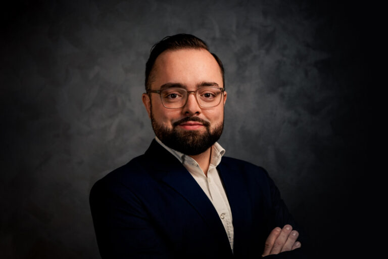 rofessionelles Studio-Porträt einer Person im Business-Outfit vor dunklem Hintergrund